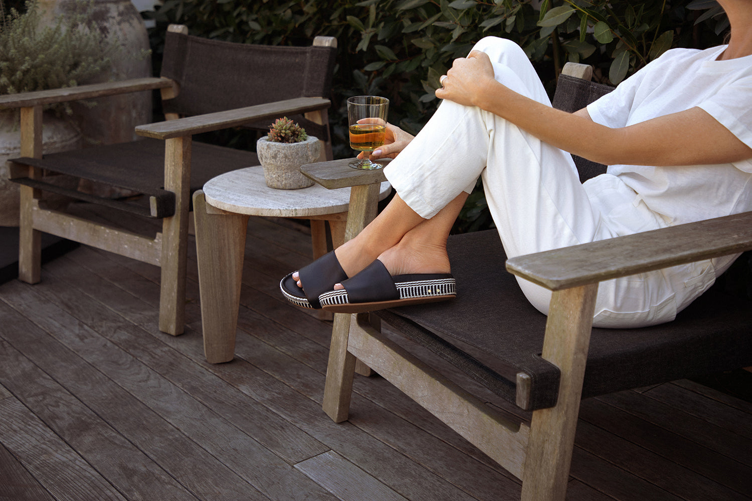Woman wearing Pelican Textile leather platform sandal with white pants and top