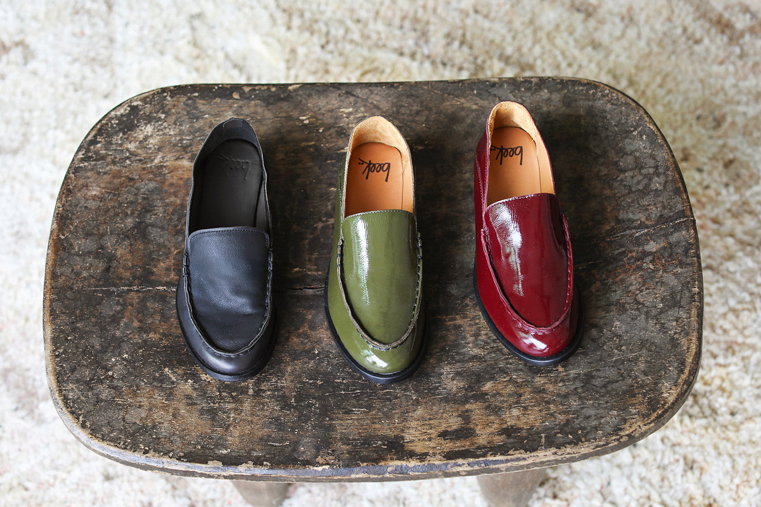 Group shot of Pepper loafers in black leather, patent leather olive and wine.