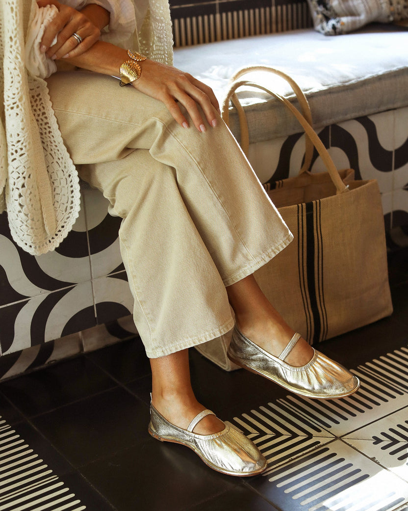 Woman wearing Petey leather ballet shoes in gold