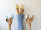 Woman wearing Phoebe leather ballet mule in glow with jeans, holding Phoebe mules in sky and gold