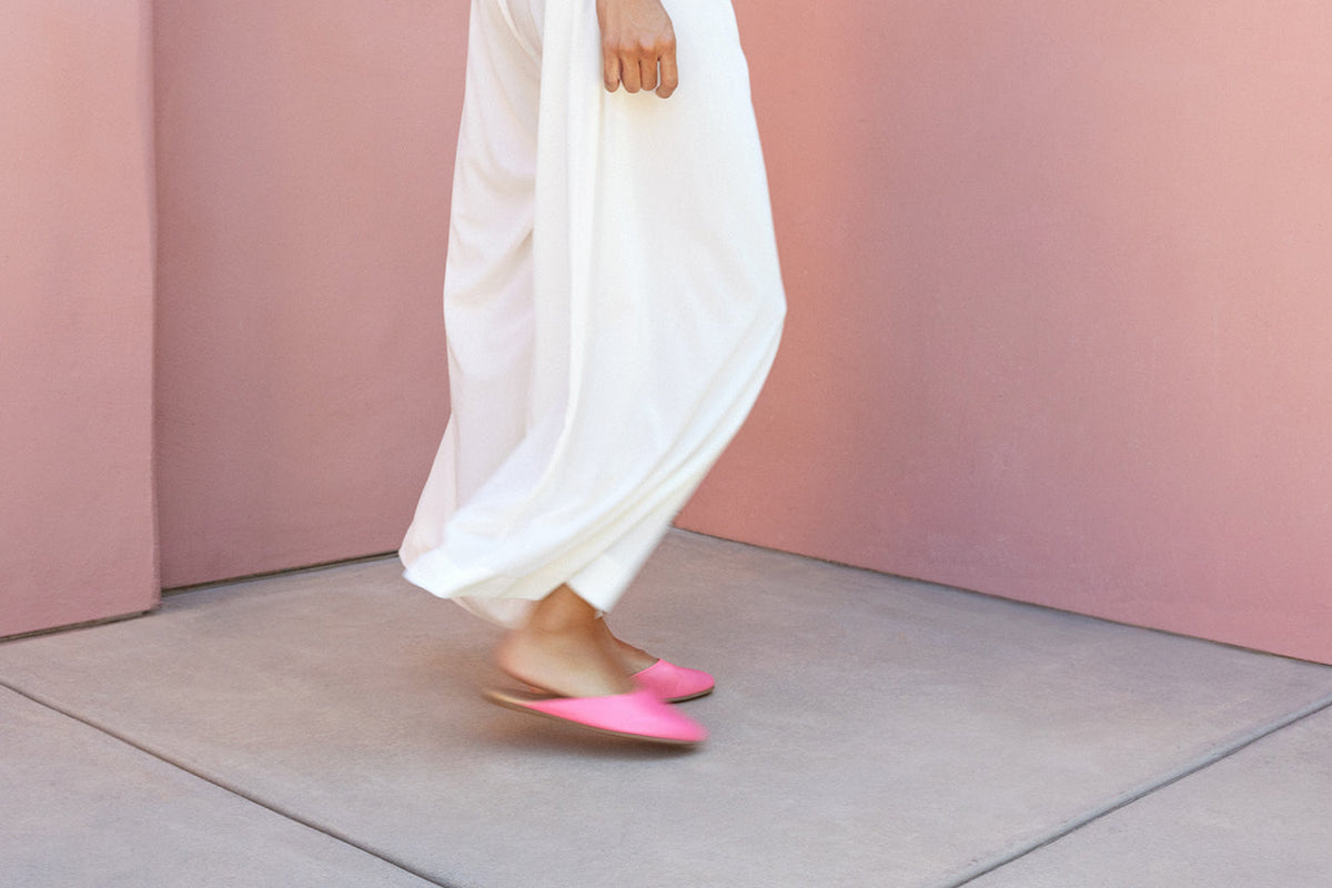 Woman wearing Phoebe leather ballet mules in peony with white pants
