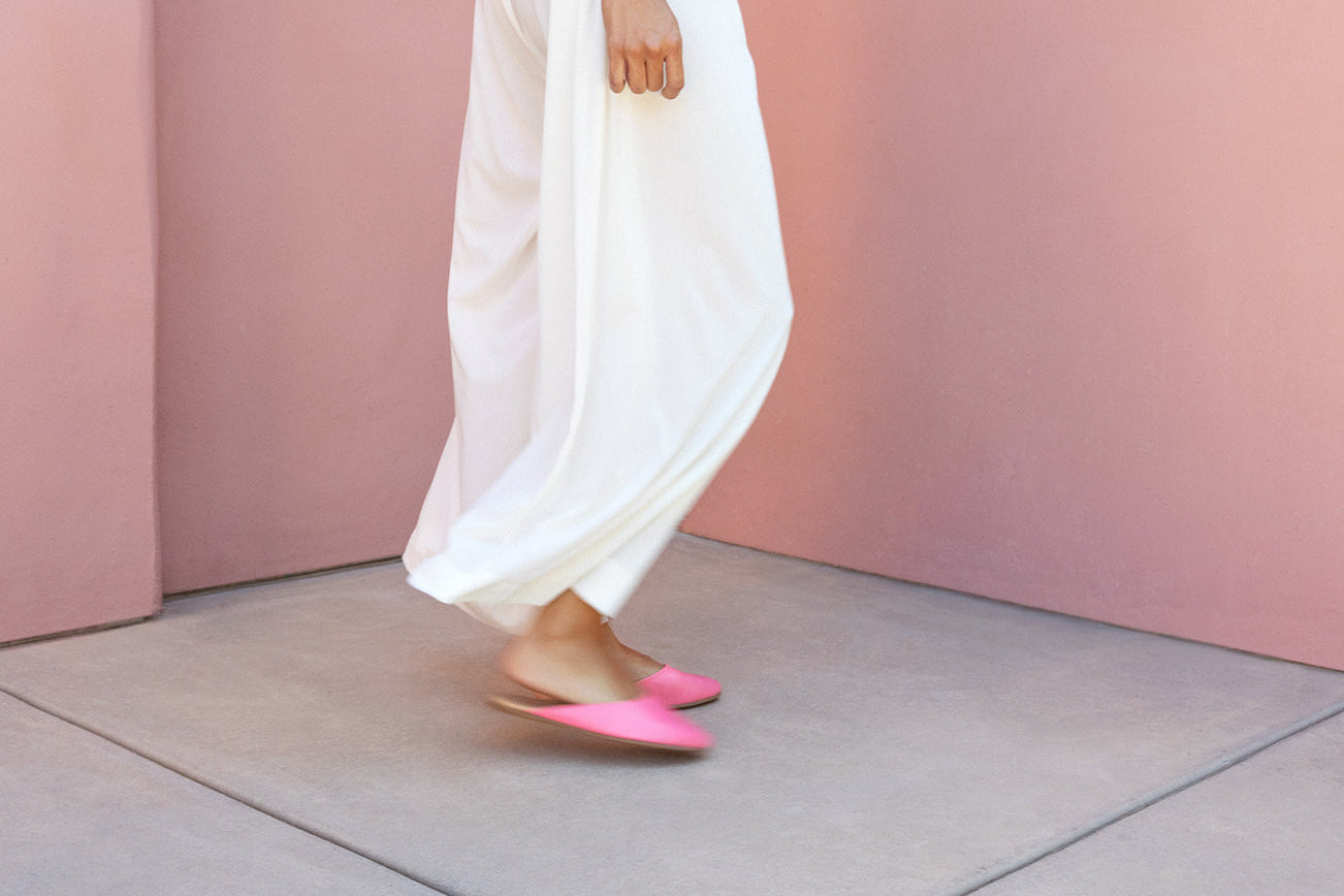 Woman wearing Phoebe leather ballet mules in peony with white pants