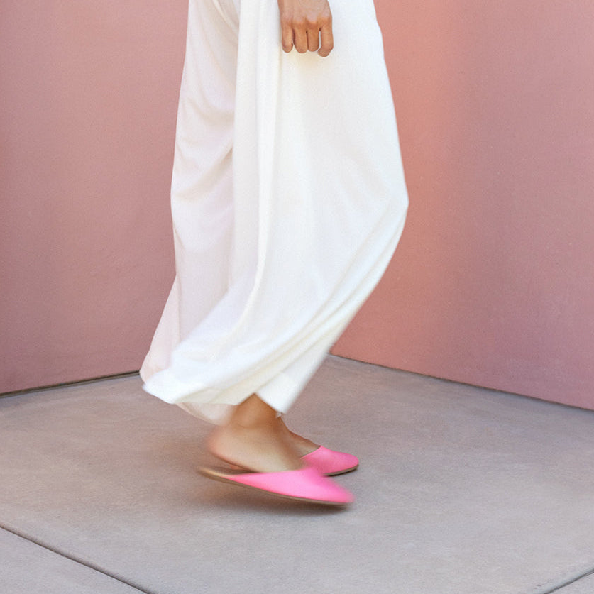 Woman wearing Phoebe leather ballet mules in peony with white pants