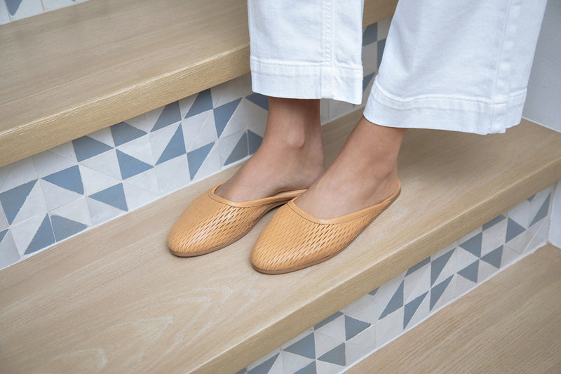 Woman wearing Phoebe Perforated leather ballet mule in honey with white pants