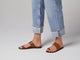 Video of woman walking in Finch leather toe-ring sandals in tan wearing cuffed jeans