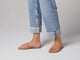 Video of woman walking in Sugarbird leather slide sandals in beach wearing cuffed jeans