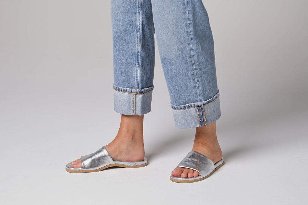 Video of woman walking in Starling leather slide sandals in silver wearing cuffed jeans