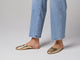 Woman walking in Phoebe leather ballet mules in gold wearing jeans
