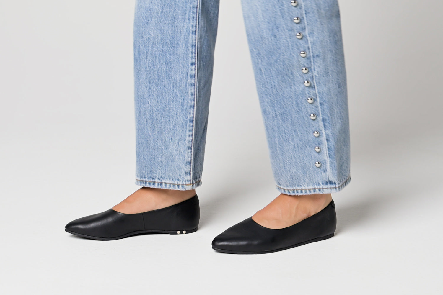 Video of woman wearing Swoop leather ballet slippers in black with jeans, walking.
