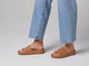 Video of woman walking in Pelican leather slide sandals in honey with jeans