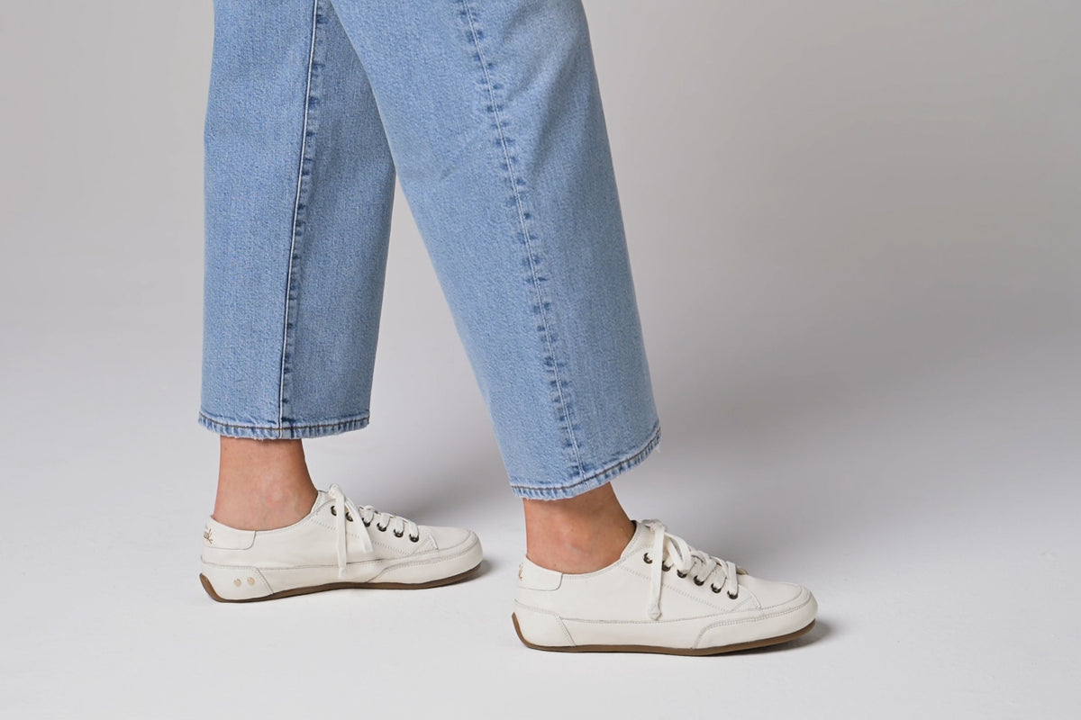 Video of woman walking in Sandpiper leather sneakers in white wearing jeans