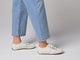 Video of woman walking in Sandpiper leather sneakers in white wearing jeans