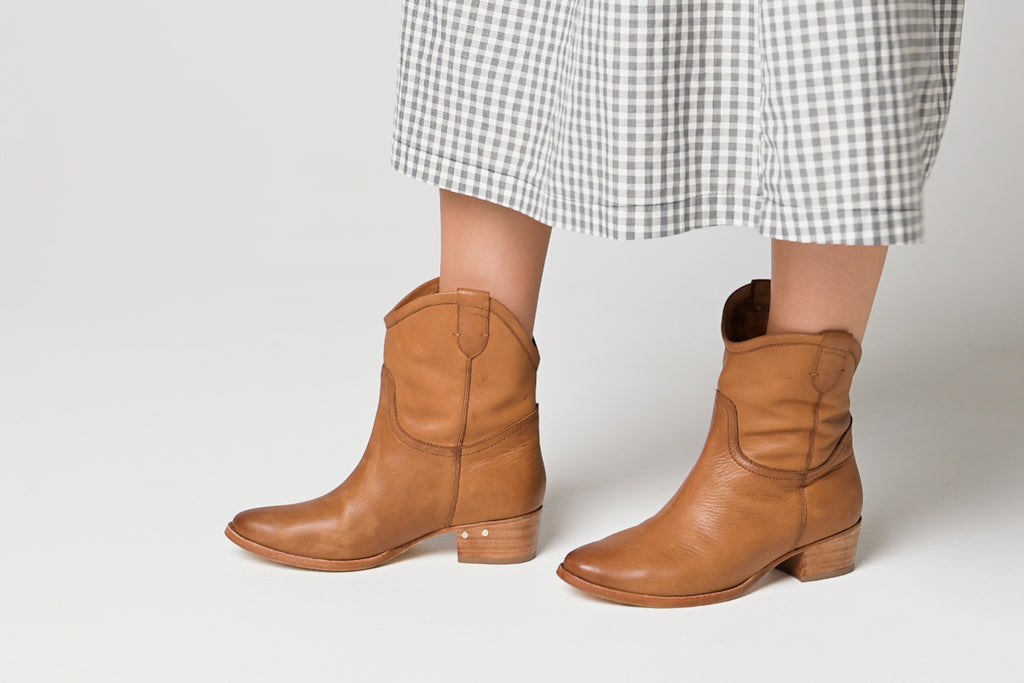 Video of women wearing Condor boots in tan with checkered dress, walking.