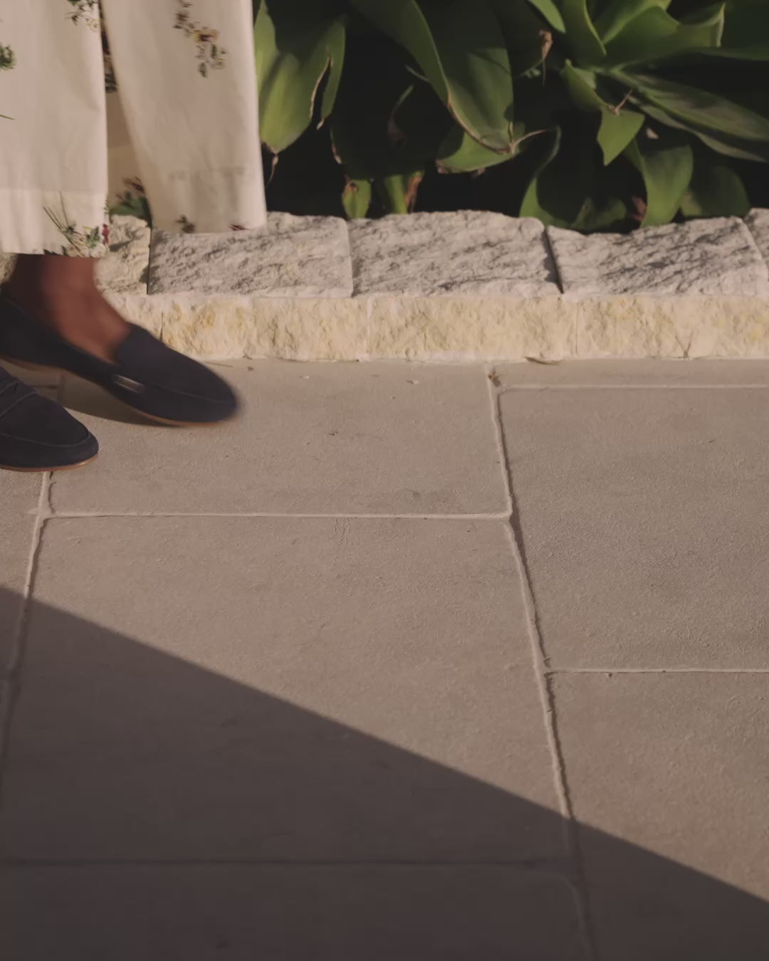 Video of woman wearing Moorhen suede loafers in navy with white floral dress, walking