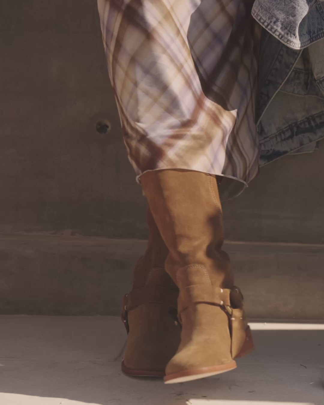 Video of woman wearing Kestrel suede knee high boots with removable strap in chestnut with plaid skirt, walking outside