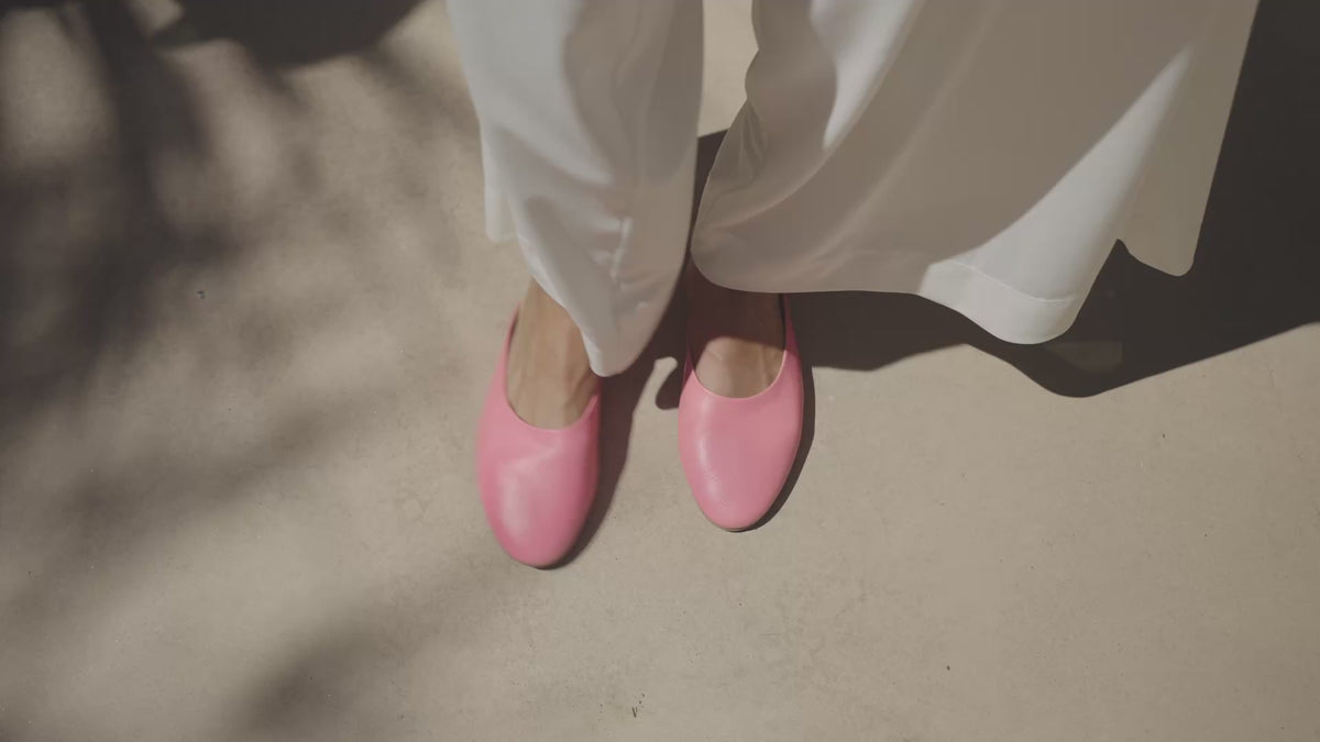 Video of woman wearing Phoebe leather ballet mules in peony with white pants, walking