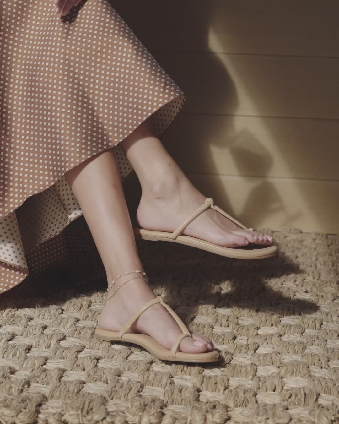 Video of woman wearing Teebird leather t-strap sandals in beach sitting and walking