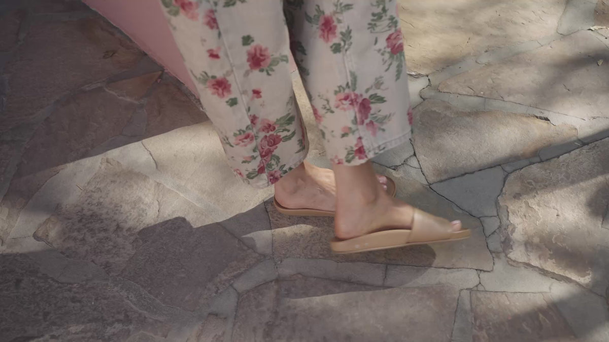 Video of woman wearing Gallito leather slide sandal in honey with floral denim pants