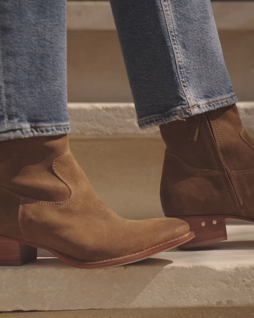 Video of woman wearing Cuervo suede boots in chestnut and jeans, walking on steps