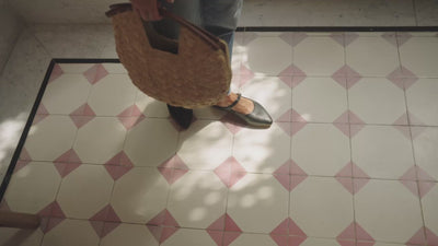 Video of woman wearing Swallow leather ballet mules in black with jeans holding a woven tote bag