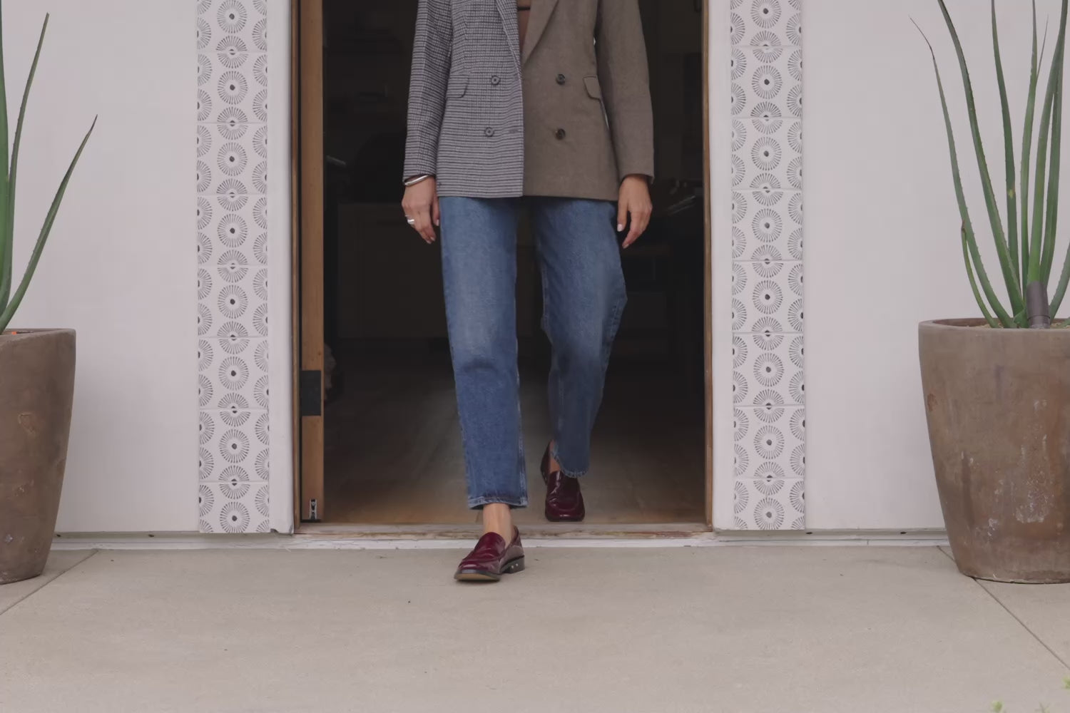 Video of woman wearing Pepper patent leather loafers in wine with jeans and jacket, walking out of door
