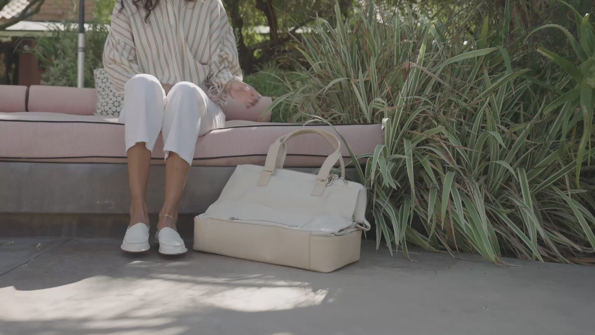 Video of woman wearing Griffin leather loafers in vanilla with white pants crrynig travel tote