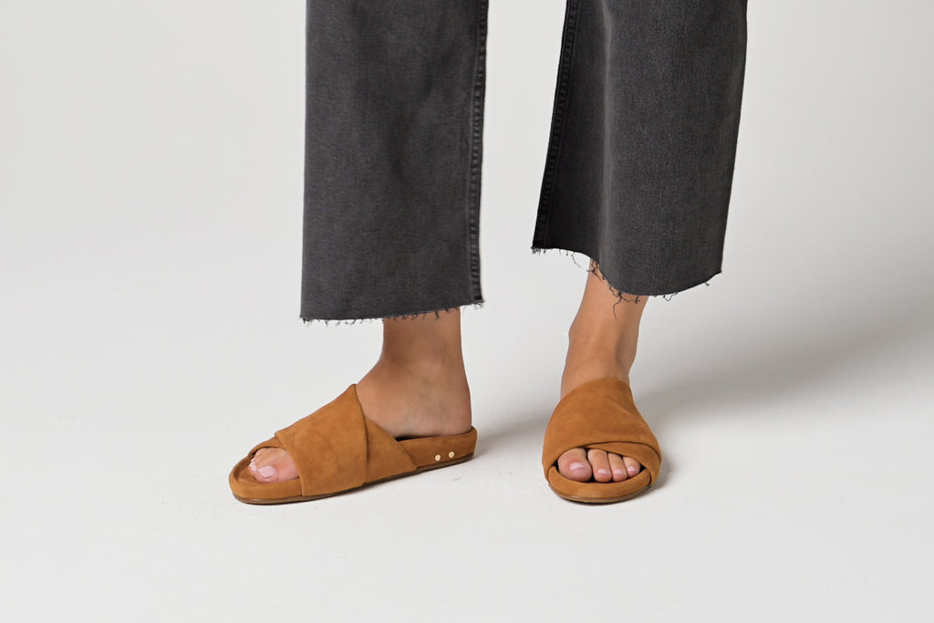 Video of woman walking wearing Kea suede slide sandals in caramel with gray pants.