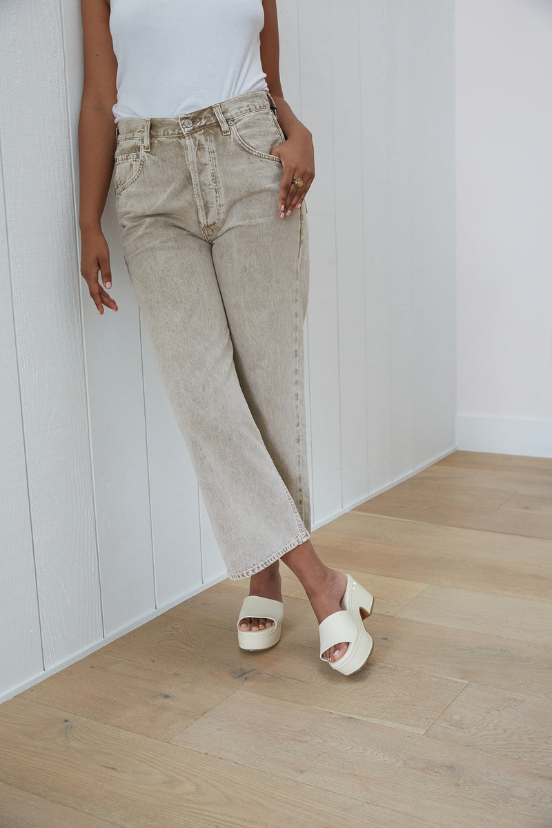 Woman wearing Prinia leather platform heel sandal in eggshell with light gray jeans