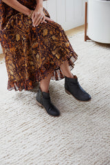 Woman wearing Quail leather boot in black with floral dress.