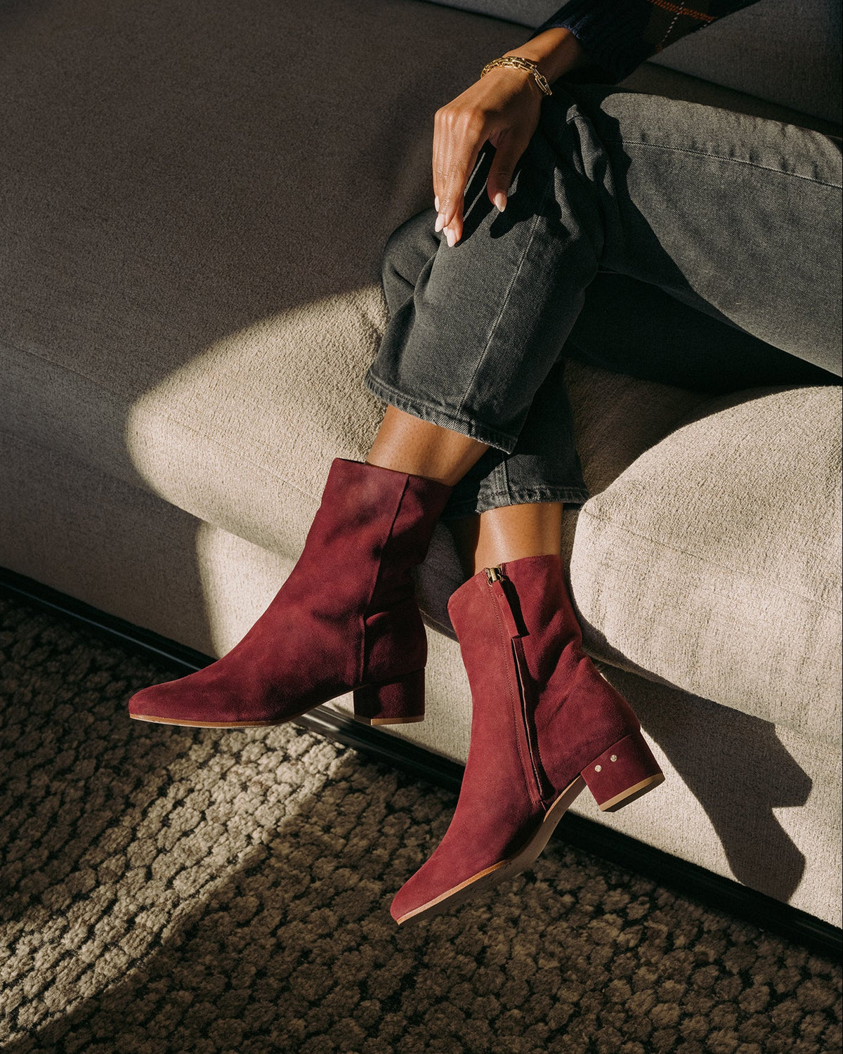 Woman wearing Raven suede boots in prune with dark jeans