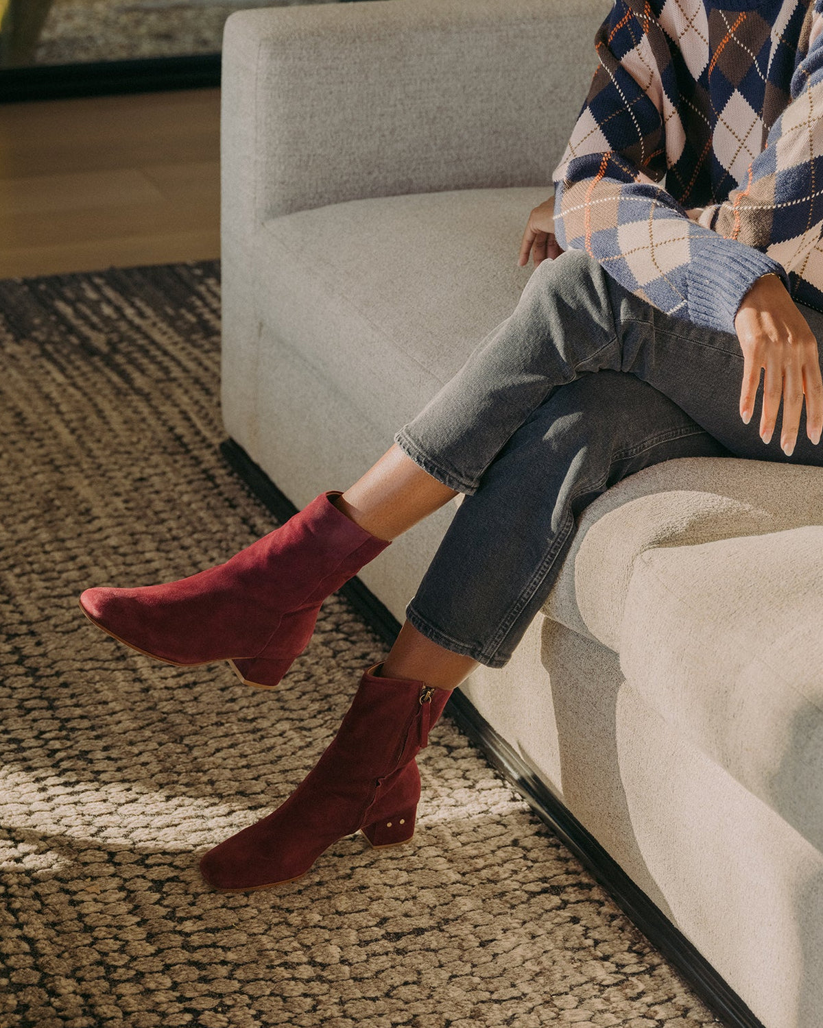 Woman wearing Raven suede boots in prune with dark jeans and sweater