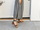 Woman wearing Sapphire leather ankle strap sandals in black with checkered dress