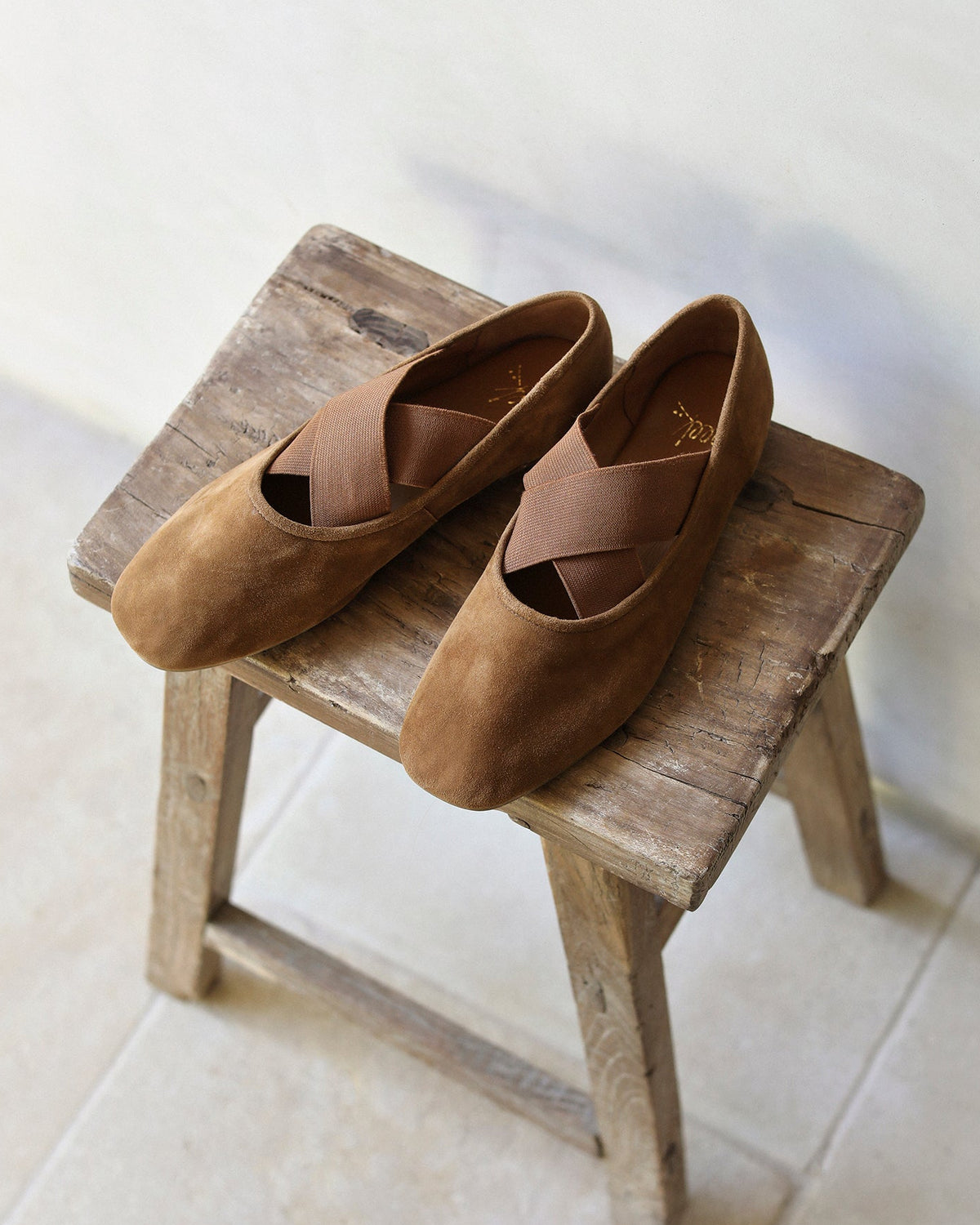 Serin suede ballet flats in toffee on a stool