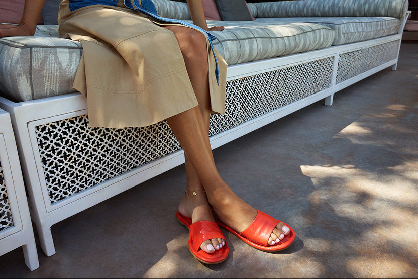 Woman wearing Songlark patent leather slide sandal in tomato 