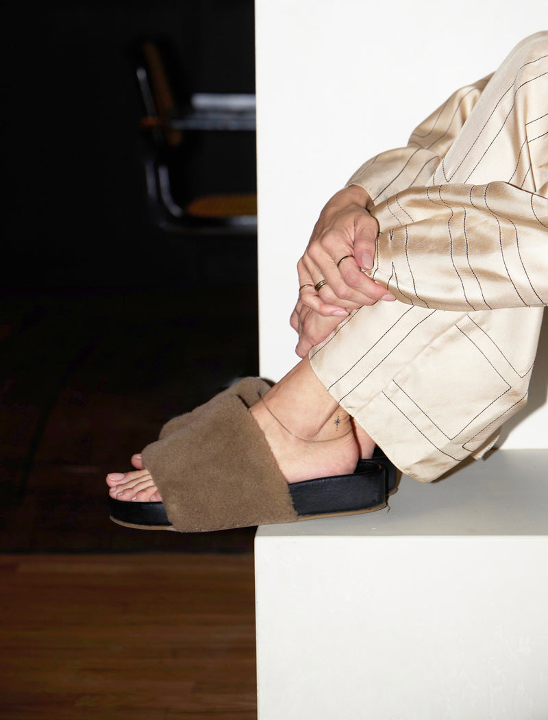 @stepsofstyle wearing Pelican Shearling sandals in bronze/black.