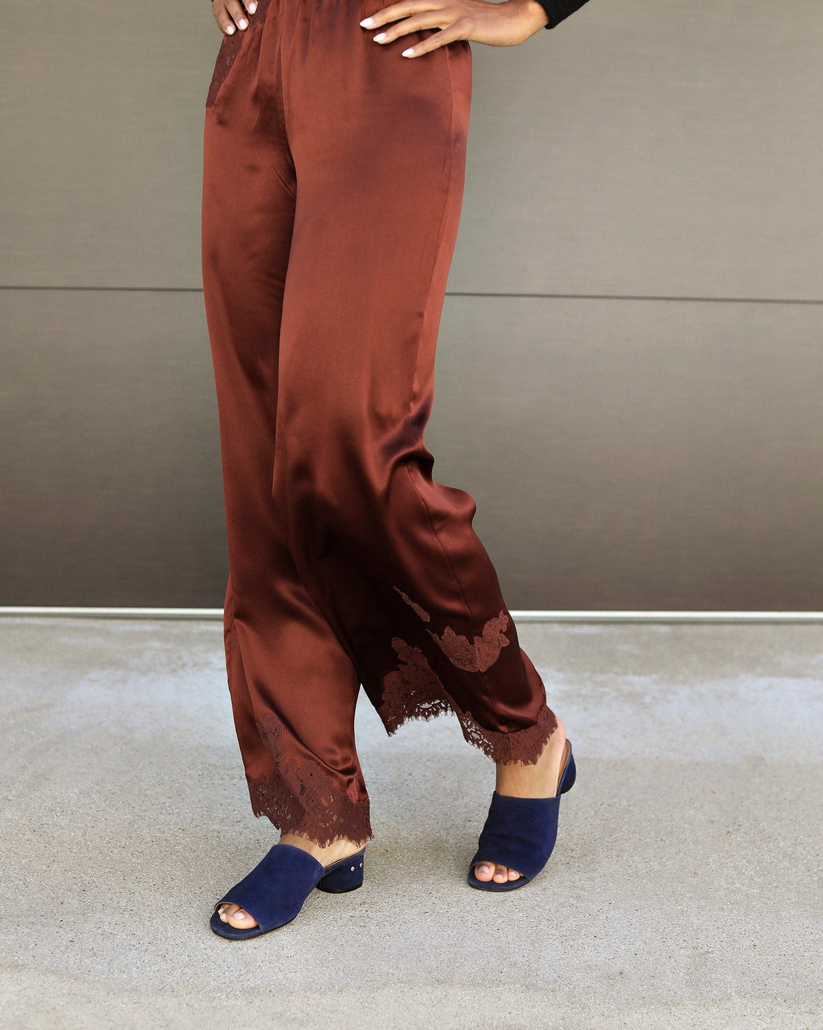 Woman wearing Stilt suede heeled sandals in navy with brown satin pants