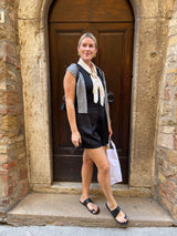 @stylingbyerica wearing Finch leather toe-ring sandal in black with black dress while traveling.