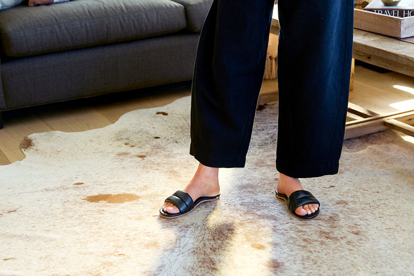 Woman wearing Sugarbird leather slide sandals in black with jeans