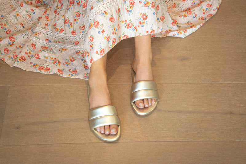 Woman wearing Sugarbird Leather Slide Sandal in platinum with floral dress