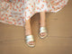 Woman wearing Sugarbird Leather Slide Sandal in platinum with floral dress