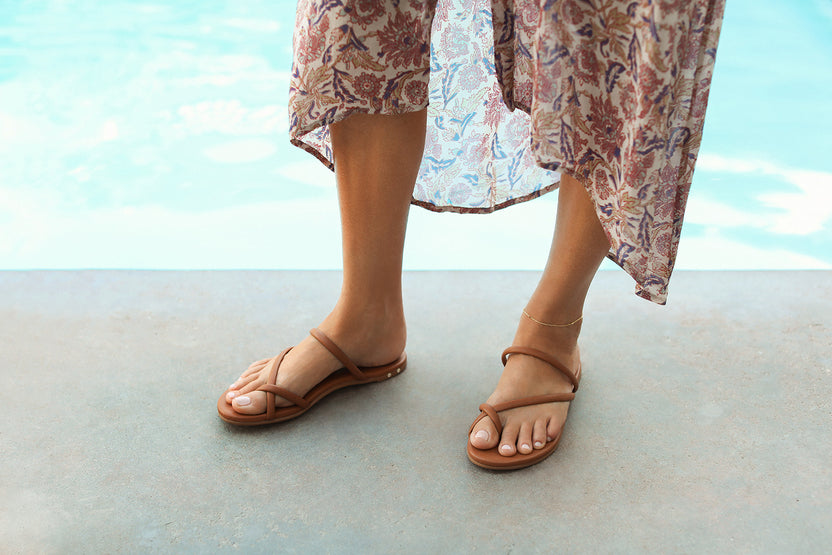 Woman wearing Sunbird leather sandals in tan with paisley print dress