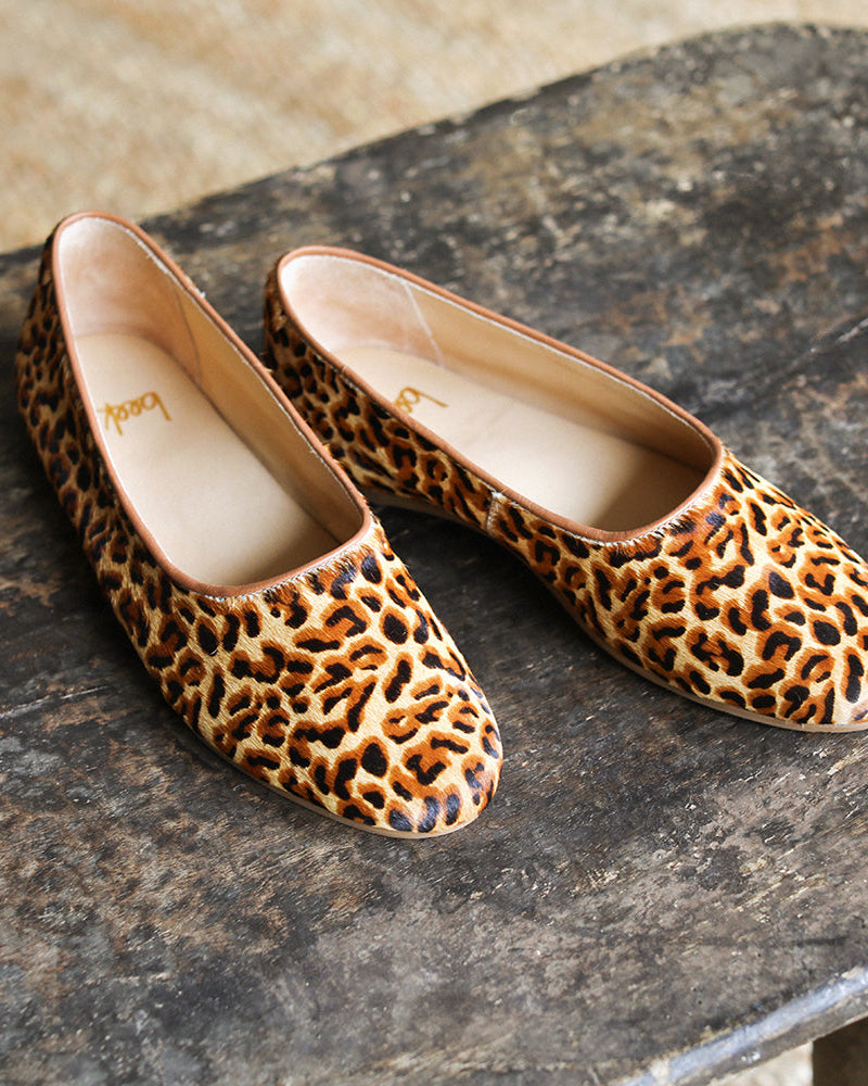 Swiftlet calf-hair and leather ballet slipper in leopard on dark stone surface