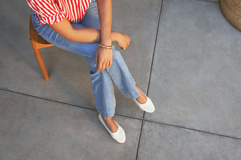 Woman wearing Swiftlet Perforated leather ballet slipper in vanilla with jeans and striped red shirt