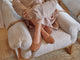 Woman wearing Swiftlet Stud leather ballet shoes with gold studs in tan sitting on chair