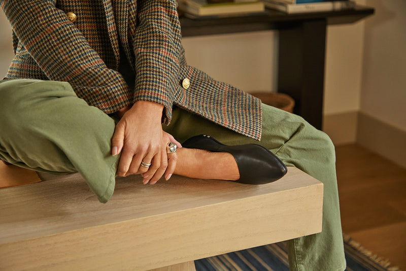 Woman wearing Swoop leather ballet slipper in black with olive pants and tweed jacket