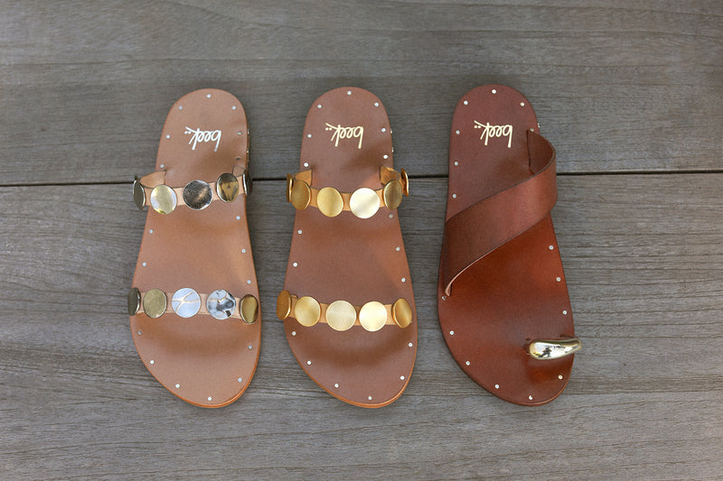 Group shot of Topaz leather slide sandals in beach, honey with Goldfinch leather toe-ring sandals in tan.