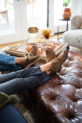 Women wearing Towhee suede lace-up wallabee shoes in chestnut and Falcon suede booties in chestnut with jeans.