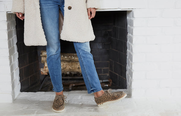 Woman wearing Towhee suede shoes in leopard with jeans and cream coat.