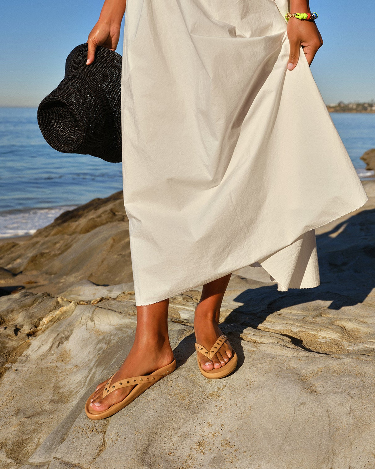Woman wearing Tringa leather sandals in beach with white dress at the beach
