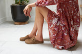 Woman wearing Vulture suede mules in chestnut with floral dress